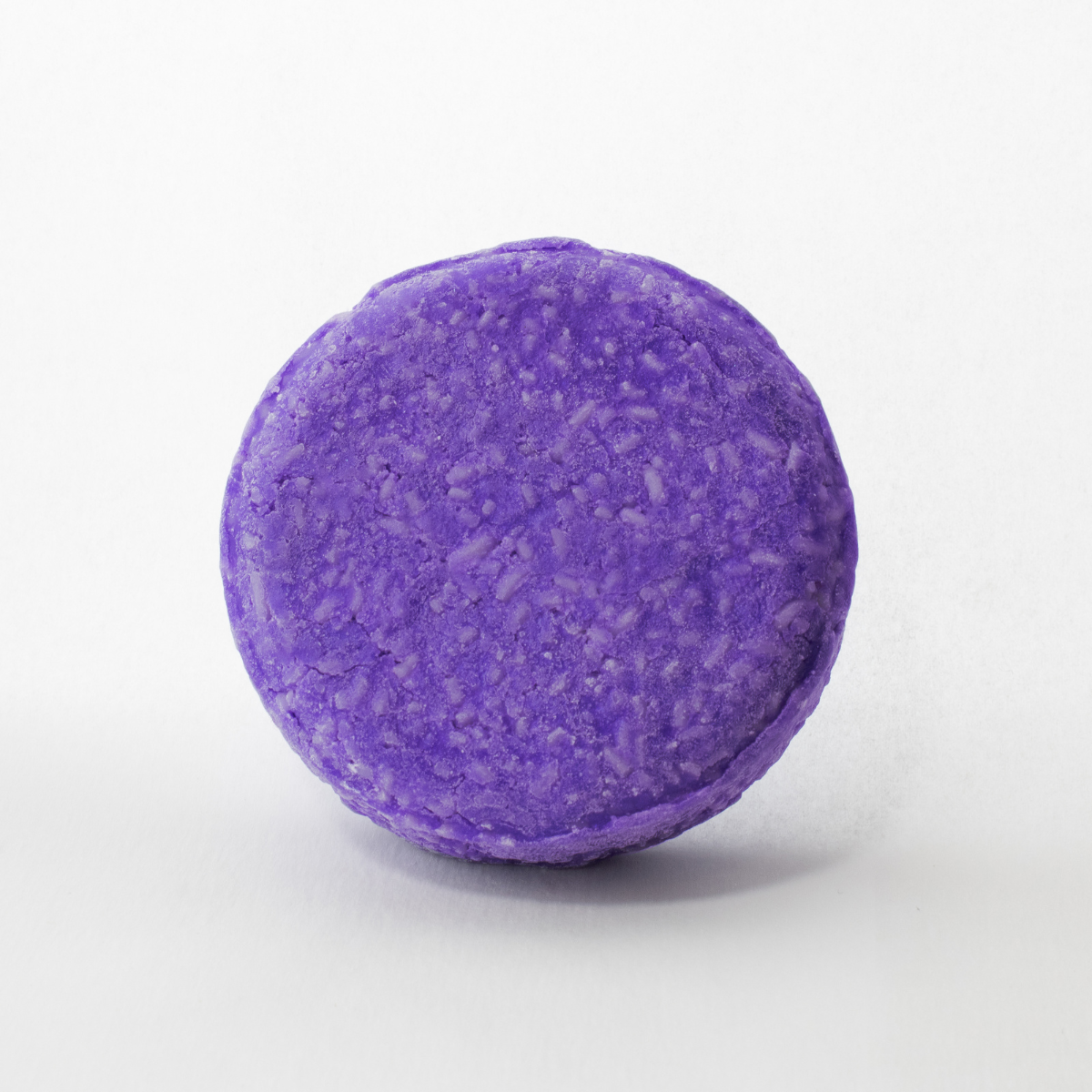 a round purple bath bomb on a white background